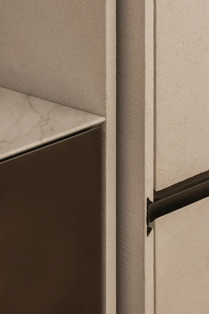 Detail van de marmeren rand van het kookeiland naast een kast met zwarte greep, Penthouse in Kortrijk, interieur Laura Calleeuw