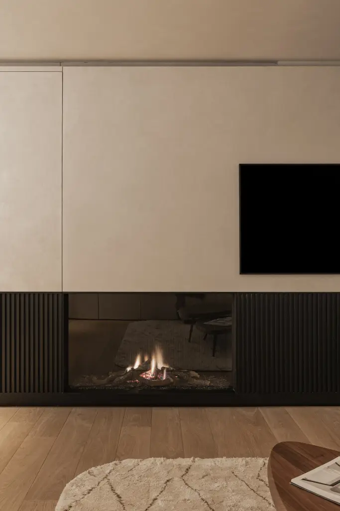 Open haard in een zwarte lamellenwand onder een televisie in een gepleisterd paneel, Penthouse in Kortrijk, interieur Laura Calleeuw