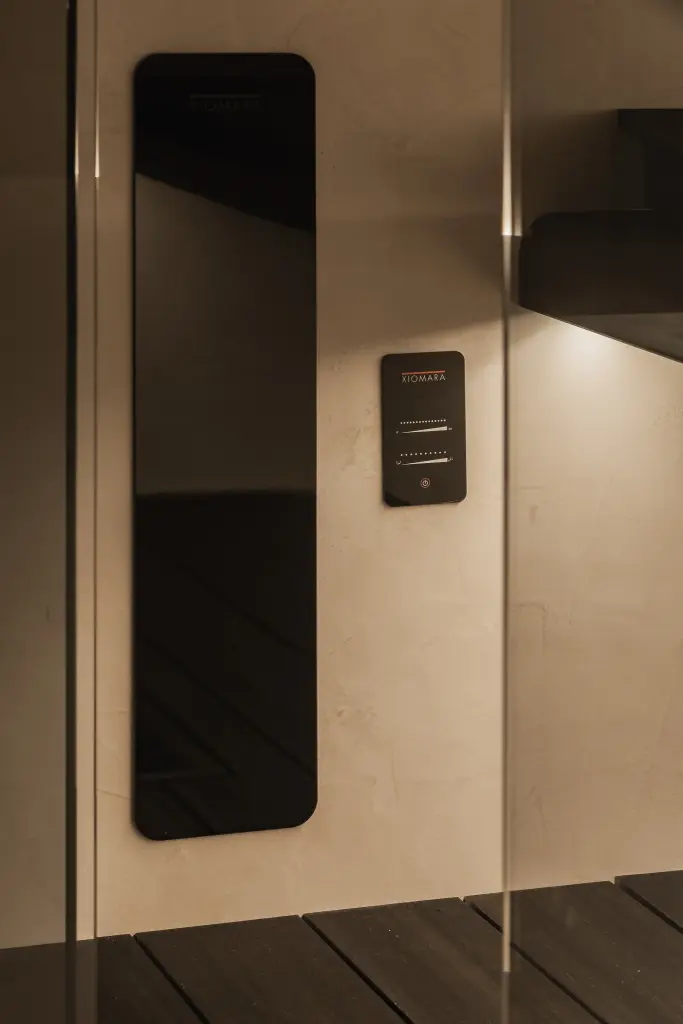 Sauna met houten bank, glazen deur, zwarte verwarmingspaneel en indirecte verlichting, Penthouse in Kortrijk, interieur Laura Calleeuw