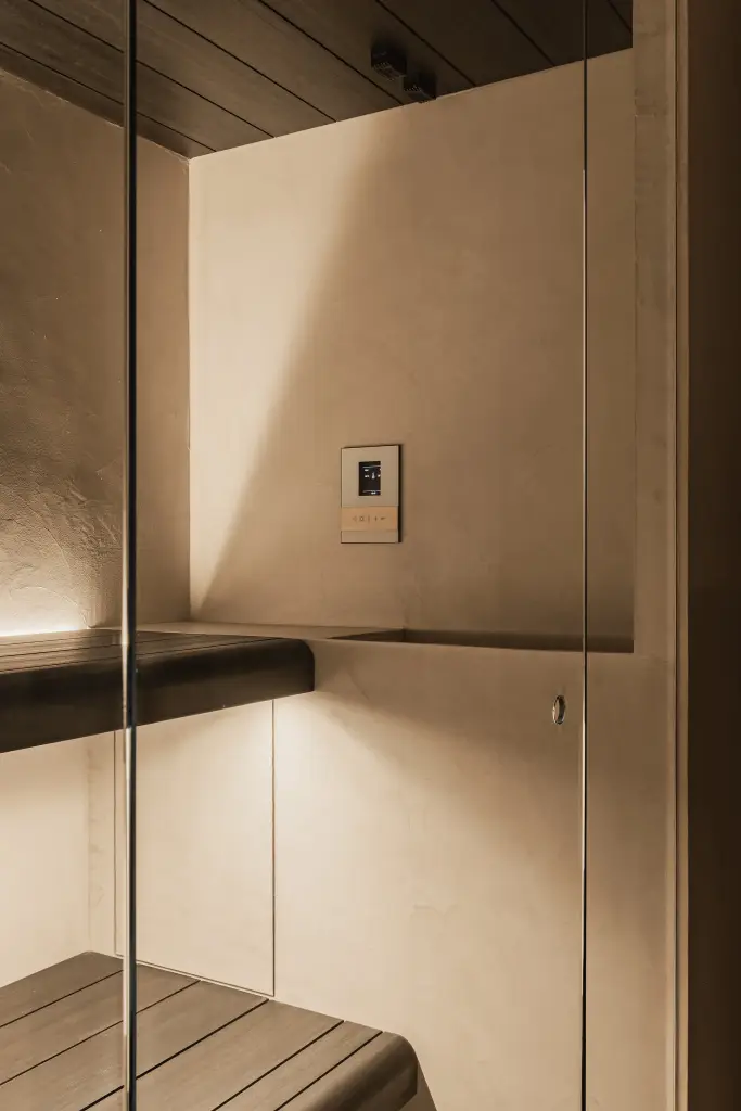 Sauna met houten bank, glazen deur, zwarte verwarmingspaneel en indirecte verlichting, Penthouse in Kortrijk, interieur Laura Calleeuw