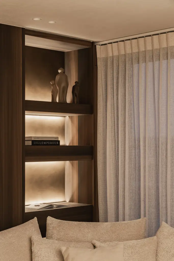 Verlichte nis in notelaar met beeldjes en een zacht gordijn, Penthouse in Kortrijk, interieur Laura Calleeuw