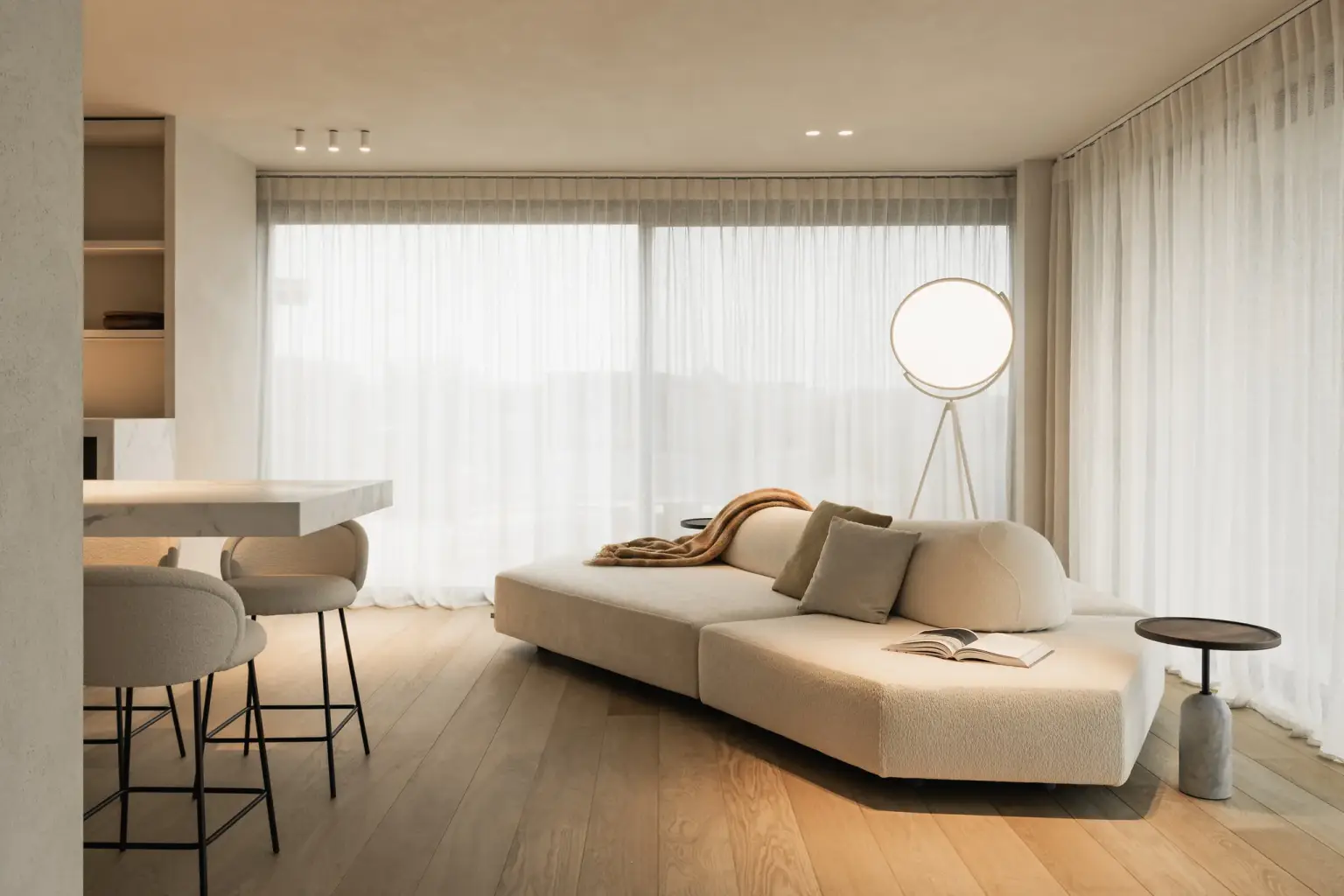 Leefruimte met lage sofa, zwarte salontafel, staande lamp en groot raam met vitrage, Penthouse in Kortrijk, interieur Laura Calleeuw