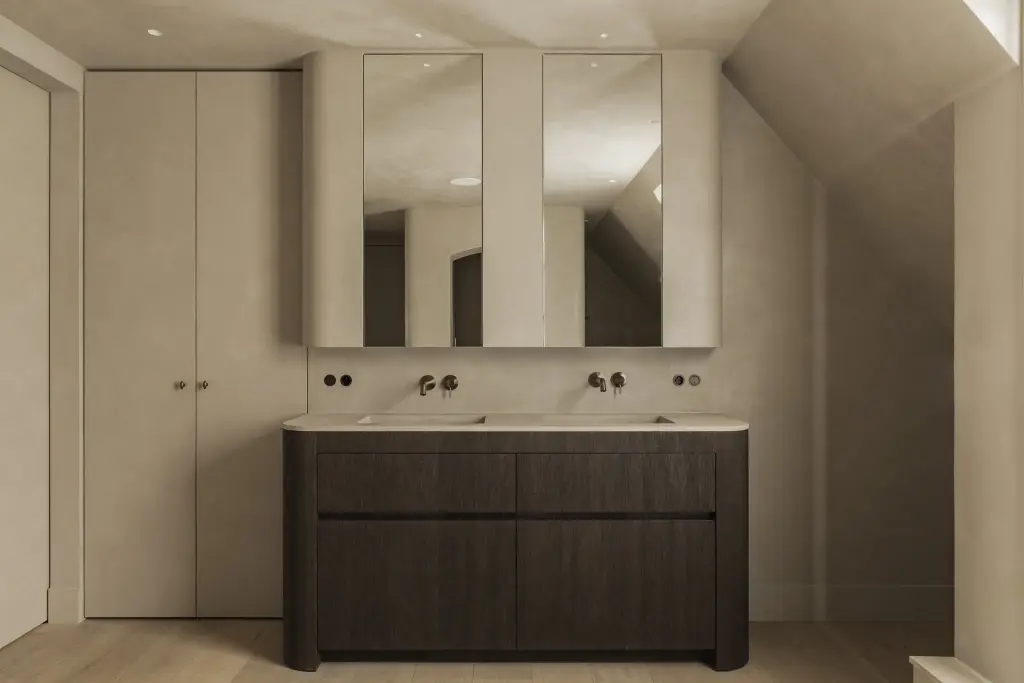 Dubbele wastafel op een donker eiken meubel onder spiegelkasten met indirect licht, Hoeve in Hansbeke, interieur Laura Calleeuw