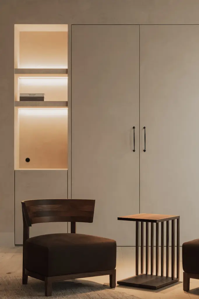 Fauteuil met houten bijzettafel voor kastdeuren met een open nis, Hoeve in Hansbeke, interieur Laura Calleeuw