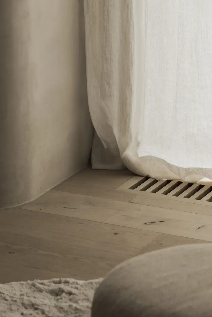 Linnen gordijn bij een ventilatierooster in het eiken parket, Hoeve in Hansbeke, interieur Laura Calleeuw