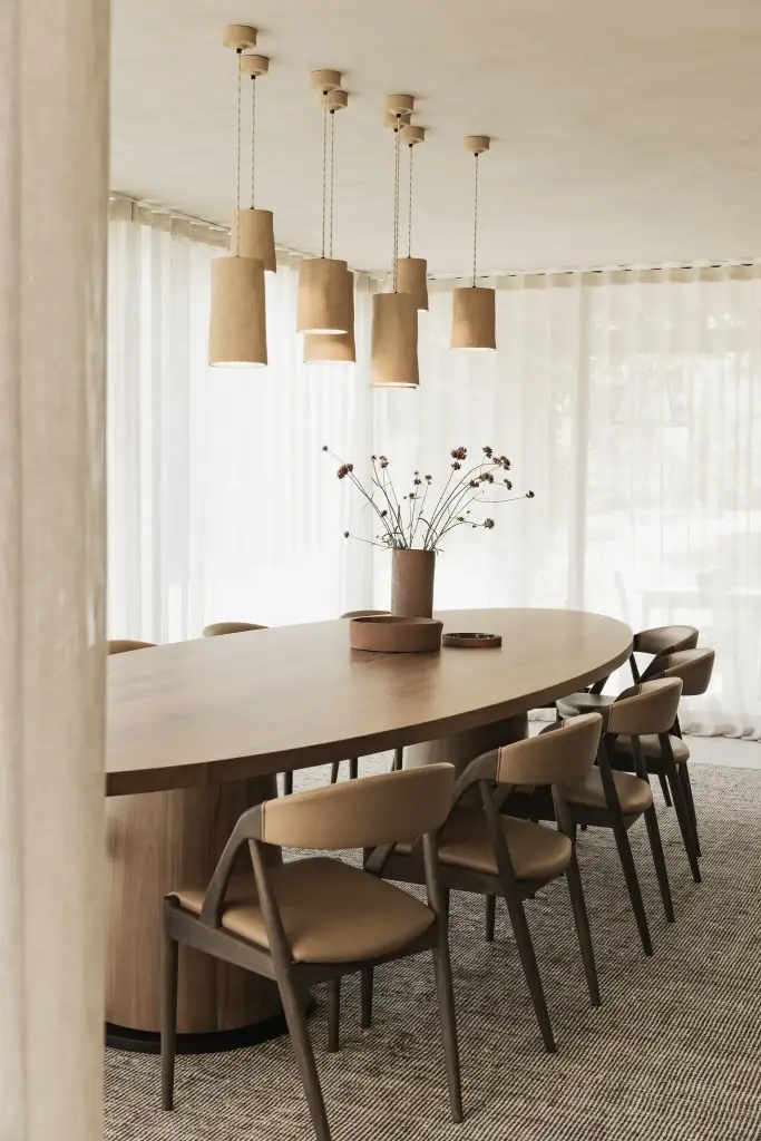 Ovale eettafel met leren stoelen, droogbloemen en hanglampen in aardewerk, Hoeve in Hansbeke, interieur Laura Calleeuw