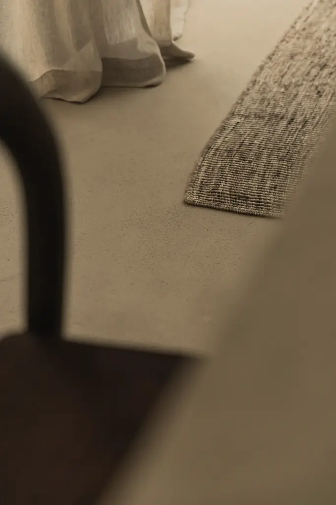 Detail van een jute tapijt en kalkpleisterhoek, Hoeve in Hansbeke, interieur Laura Calleeuw