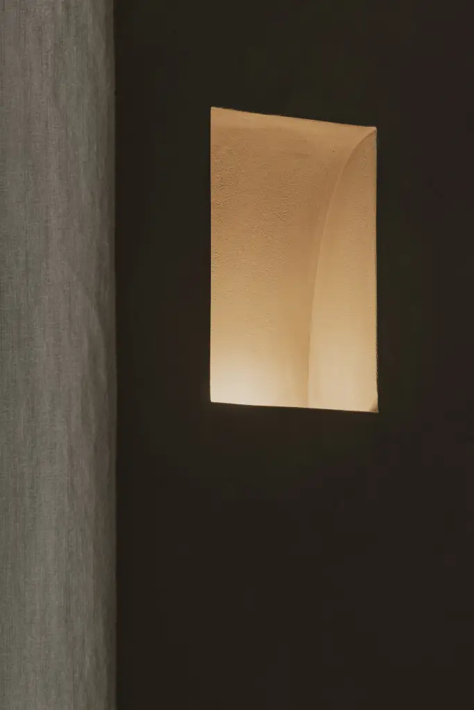 Verlichte ronde nis in een donkere wand, Hoeve in Hansbeke, interieur Laura Calleeuw