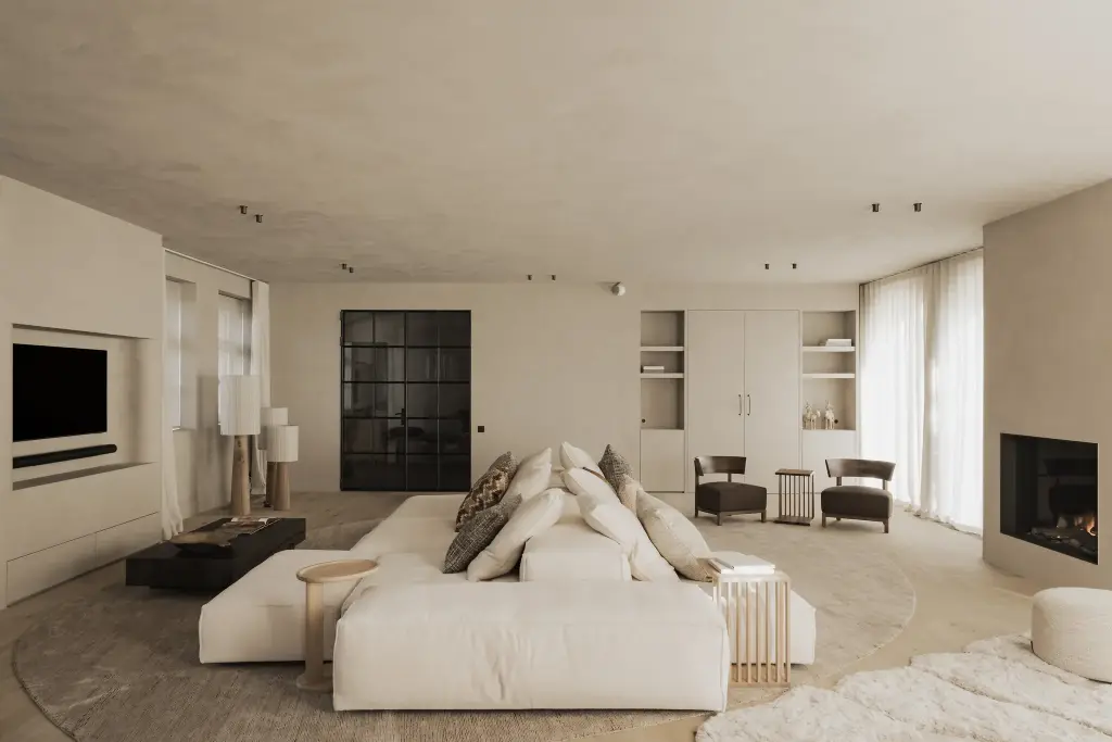 Ruime woonkamer met lage hoeksofa, open haard, televisie en stalen deuren, Hoeve in Hansbeke, interieur Laura Calleeuw