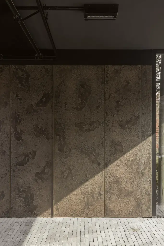 Panelen in betonlook onder de rail van de garagepoort, a space that changes with the rhythm of the day, interieur Laura Calleeuw