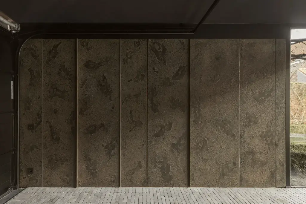 Garagepoort afgewerkt met panelen in gepatineerde betonlook naast gebeitst houten kasten, a space that changes with the rhythm of the day, interieur Laura Calleeuw