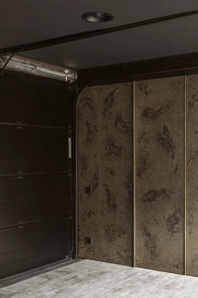 Garagepoort afgewerkt met panelen in gepatineerde betonlook naast gebeitst houten kasten, a space that changes with the rhythm of the day, interieur Laura Calleeuw