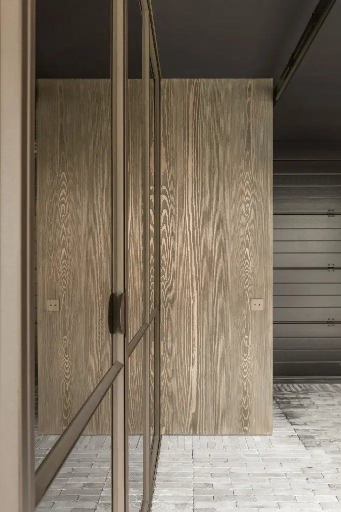 Stalen glasdeur voor een gebeitste houten kastdeur op een tegelvloer in klinkers, a space that changes with the rhythm of the day, interieur Laura Calleeuw