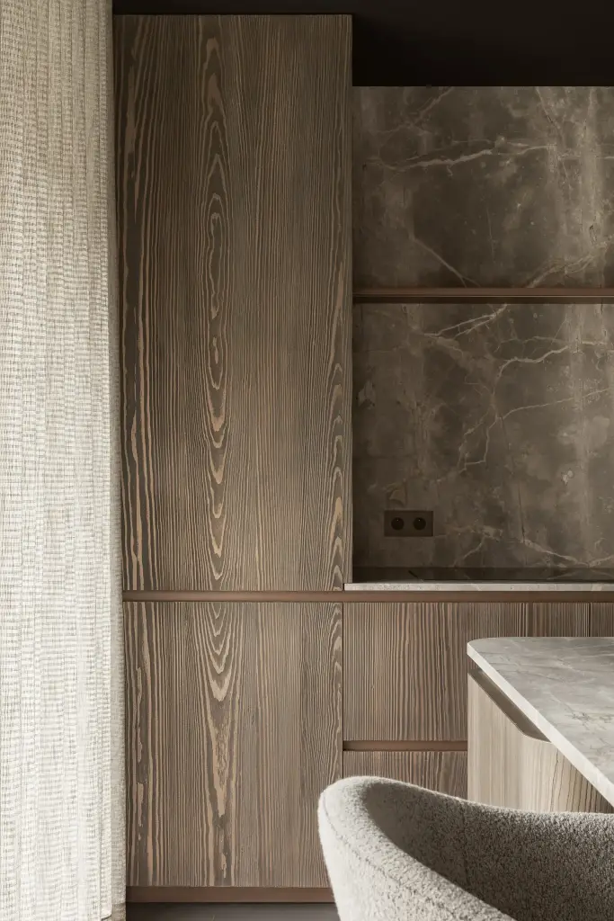 Hoge kast in gebeitst hout naast een natuurstenen nis met stopcontacten en een barkruk, a space that changes with the rhythm of the day, interieur Laura Calleeuw
