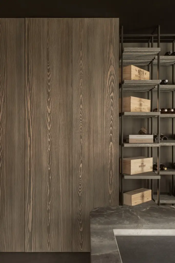 Gebeitste houten kastdeur naast het wijnrek en een natuurstenen blad, a space that changes with the rhythm of the day, interieur Laura Calleeuw