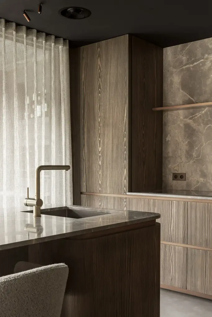 Keukenblok met natuurstenen wand, spoelbak, messing kraan, vitrage en barkruk, a space that changes with the rhythm of the day, interieur Laura Calleeuw