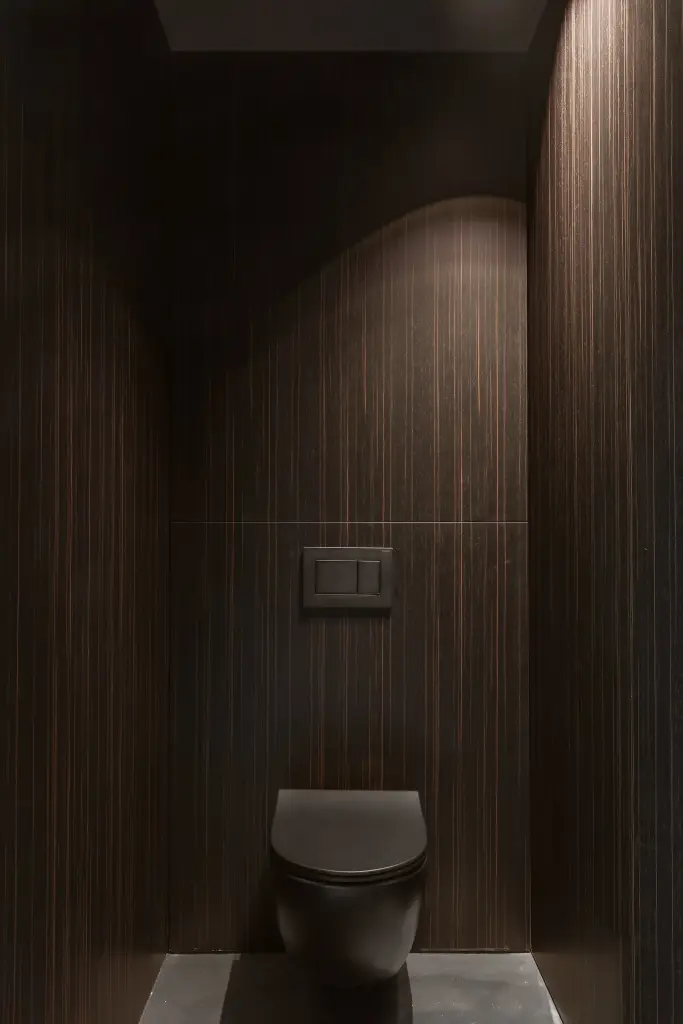 Toilet met gebogen ribbelwand in donker hout en zwart hangtoilet, a space that changes with the rhythm of the day, interieur Laura Calleeuw