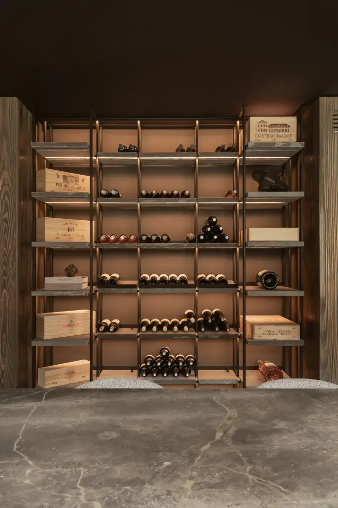 Wijnrek met kratten en flessen voor een natuurstenen blad, a space that changes with the rhythm of the day, interieur Laura Calleeuw