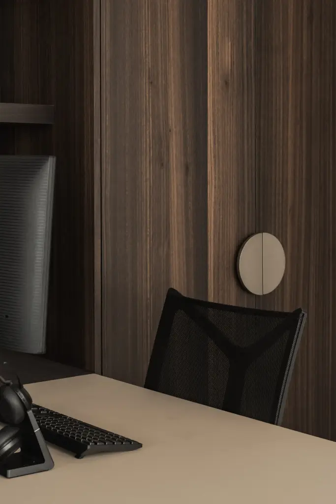 Bureau met bureaustoel en toetsenbord naast een kastdeur met ronde greep, Kantoor KBC in Ardooie, interieur Laura Calleeuw