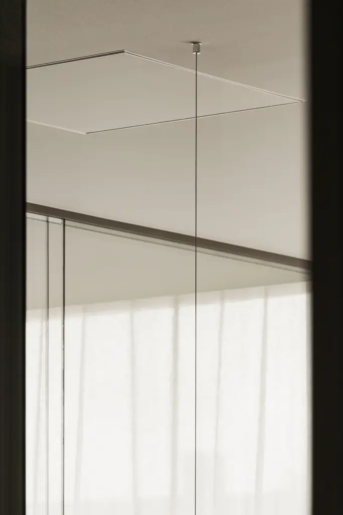 Kantoor met donker houten bureau, schermen op een arm, lange lamp en vitrage, Kantoor KBC in Ardooie, interieur Laura Calleeuw
