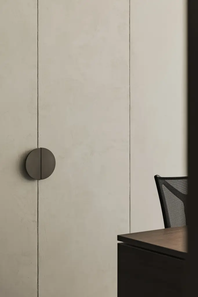 Kastdeur in kalkpleister met een ronde greep naast het bureau, Kantoor KBC in Ardooie, interieur Laura Calleeuw