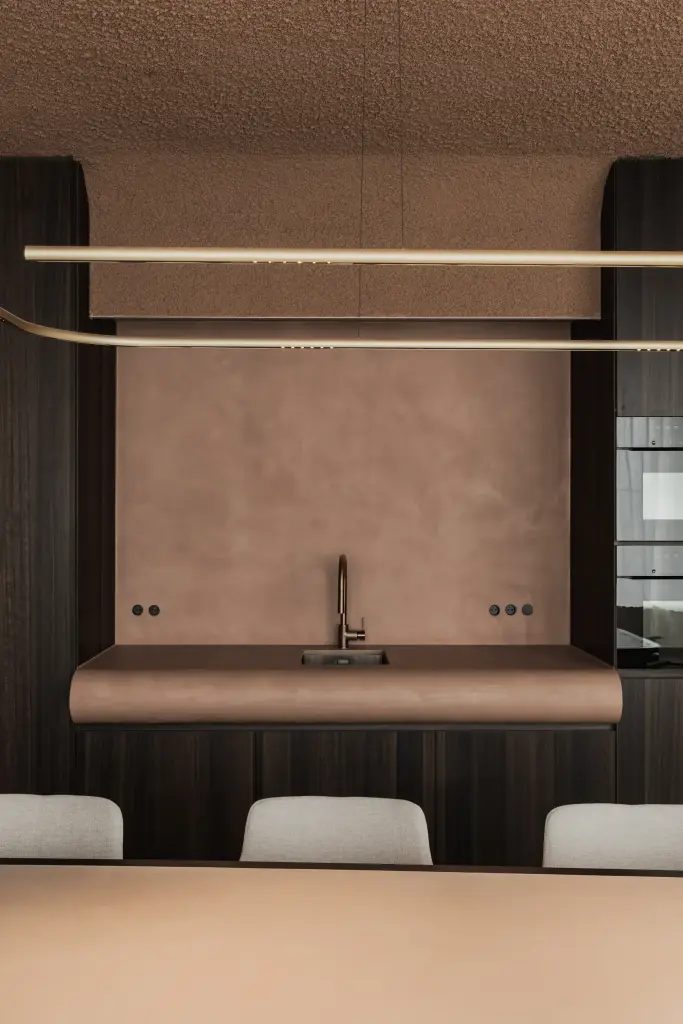 Gebogen terracotta blad met kraan, ronde greep en een lichtlijn boven de vergadertafel, Kantoor KBC in Ardooie, interieur Laura Calleeuw