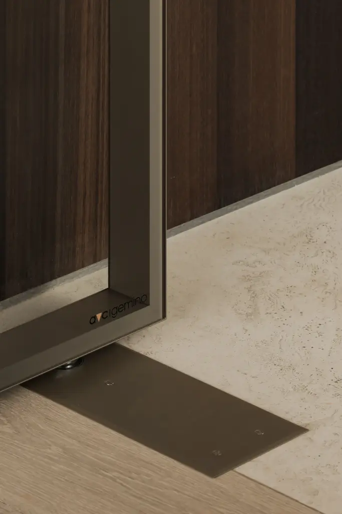 Onderkant van een stalen glasdeur met vloerscharnier op een travertijnen vloer, Kantoor KBC in Ardooie, interieur Laura Calleeuw