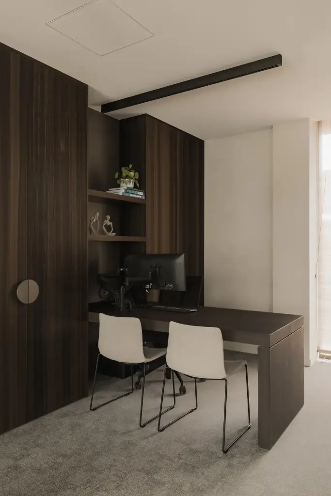 Werkplek met bureau, twee witte stoelen en kasten in donker hout, Kantoor KBC in Ardooie, interieur Laura Calleeuw