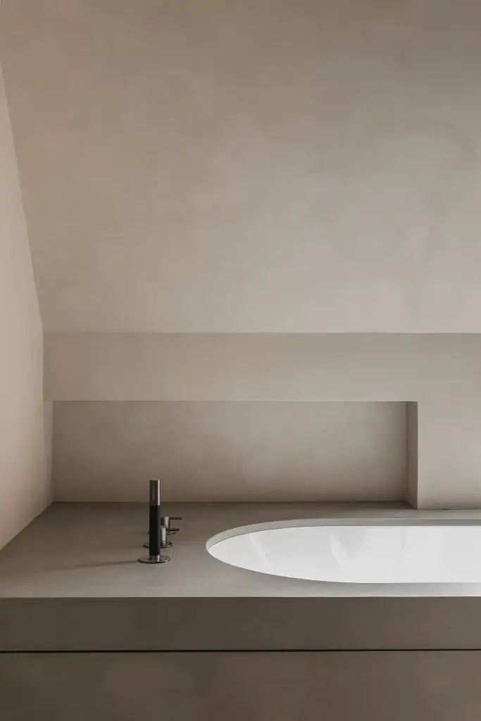 Badkamer onder het schuine dak met ligbad, hangtoilet en stalen glaswand, where architecture creates space for experience, interieur Laura Calleeuw