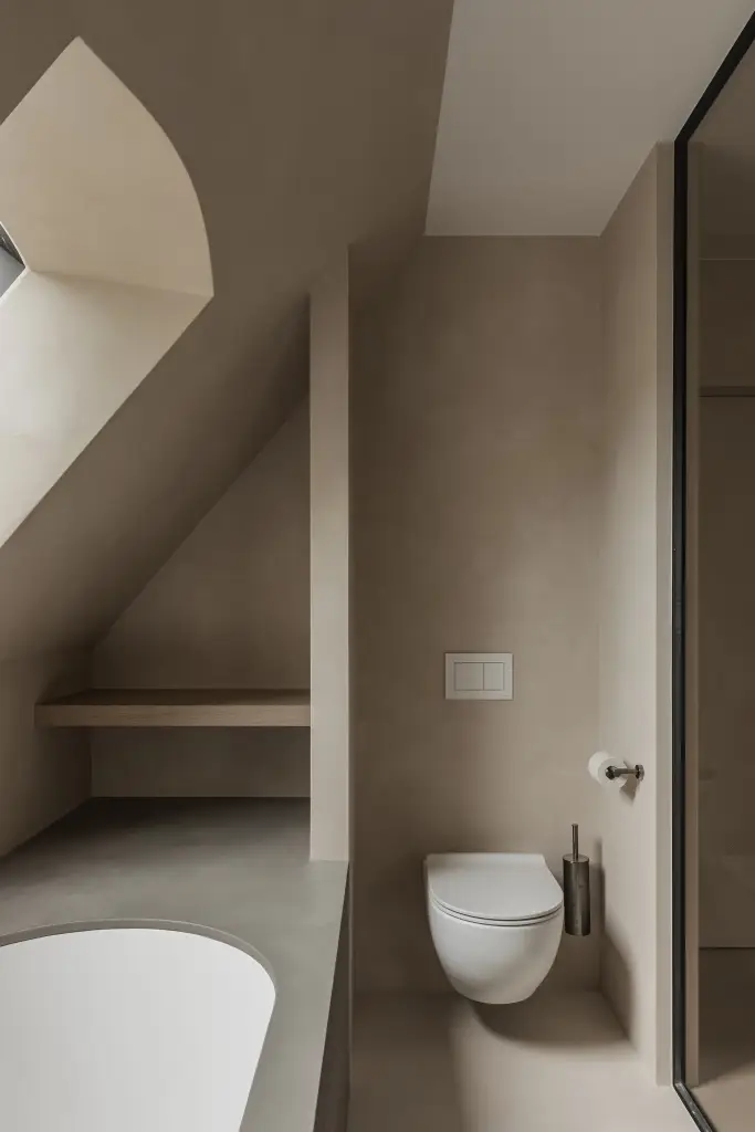 Badkamer onder het schuine dak met ligbad, hangtoilet en stalen glaswand, where architecture creates space for experience, interieur Laura Calleeuw