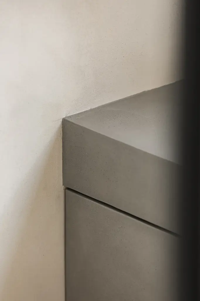 Detail van de rand van een inbouwbad in microcement, where architecture creates space for experience, interieur Laura Calleeuw