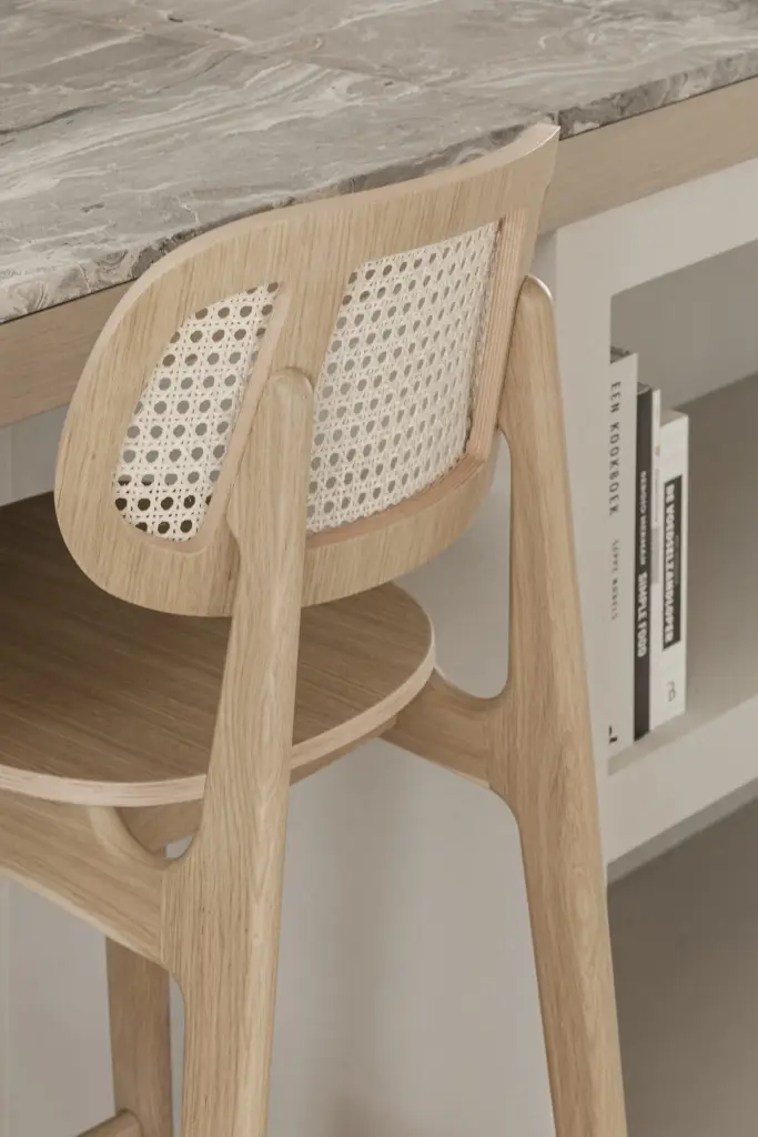 Detail van een eikenhouten barkruk met rotan rugleuning, where architecture creates space for experience, interieur Laura Calleeuw