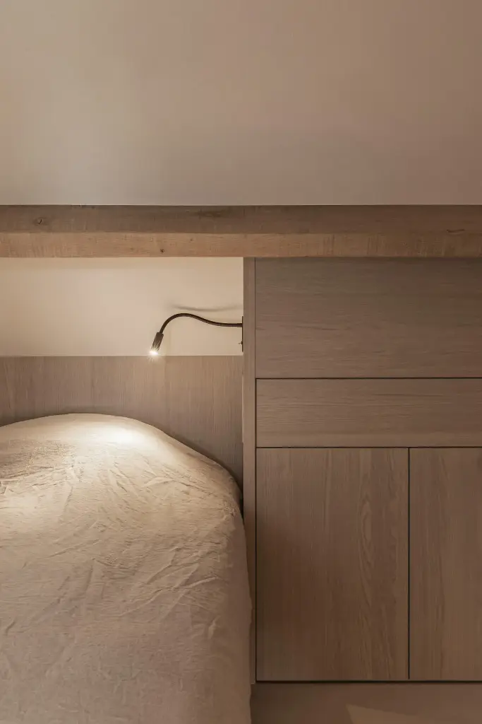 Bed met leeslamp en nis in eikenhouten kastwerk, where architecture creates space for experience, interieur Laura Calleeuw