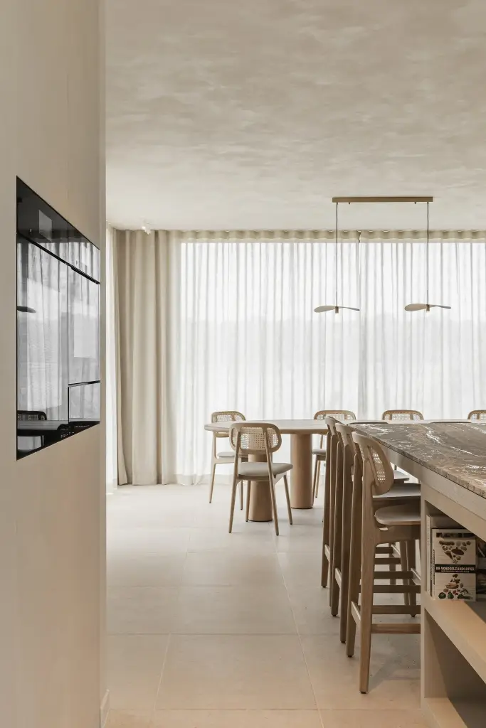 Doorkijk naar de eetruimte met lange tafel, hanglampen en barkrukken, where architecture creates space for experience, interieur Laura Calleeuw