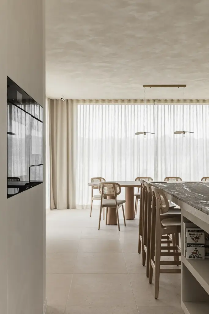 Doorkijk naar de eetruimte met lange tafel, hanglampen en barkrukken, where architecture creates space for experience, interieur Laura Calleeuw