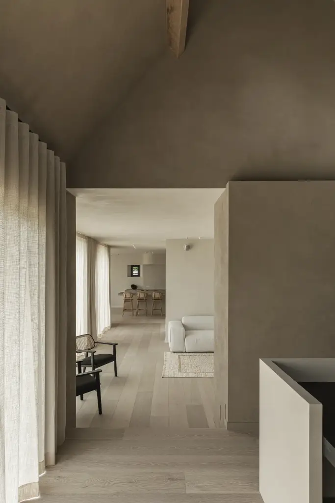 Doorkijk vanuit de werkhoek naar de woonkamer langs een linnen gordijn, where architecture creates space for experience, interieur Laura Calleeuw