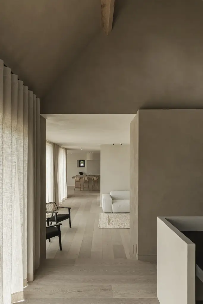 Doorkijk vanuit de werkhoek naar de woonkamer langs een linnen gordijn, where architecture creates space for experience, interieur Laura Calleeuw