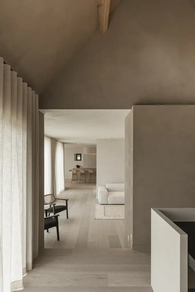 Doorkijk vanuit de werkhoek naar de woonkamer langs een linnen gordijn, where architecture creates space for experience, interieur Laura Calleeuw