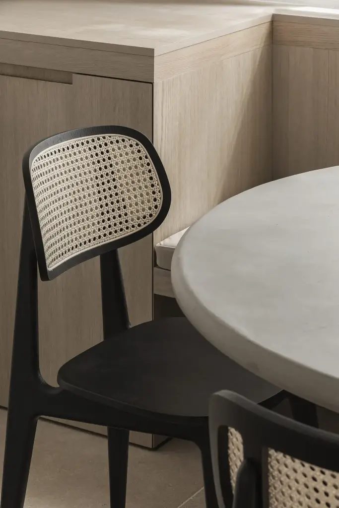 Eethoek met rotan stoelen, ronde tafel en zitbank in eiken, where architecture creates space for experience, interieur Laura Calleeuw