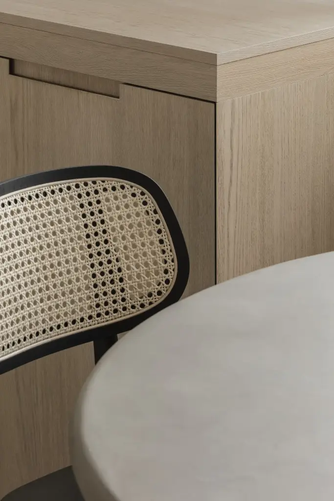 Eethoek met rotan stoelen, ronde tafel en zitbank in eiken, where architecture creates space for experience, interieur Laura Calleeuw