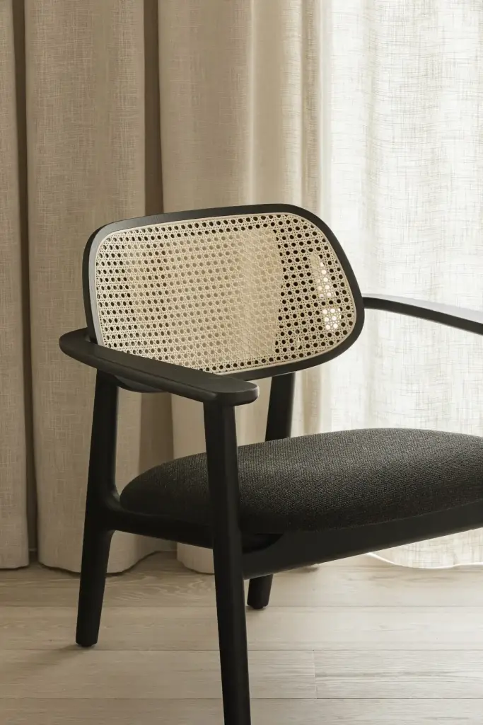 Fauteuil met rotan rugleuning en zwart houten frame, where architecture creates space for experience, interieur Laura Calleeuw