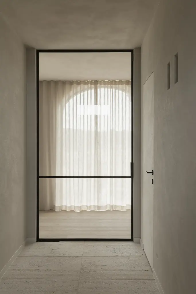 Gang met zwarte stalen glaswand en boogvormig raam met linnen gordijn, where architecture creates space for experience, interieur Laura Calleeuw