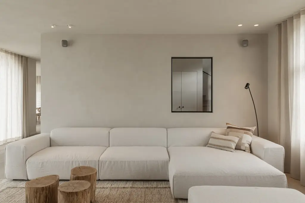 Witte hoekzetel met zwarte spiegel en boomstamtafeltjes, where architecture creates space for experience, interieur Laura Calleeuw