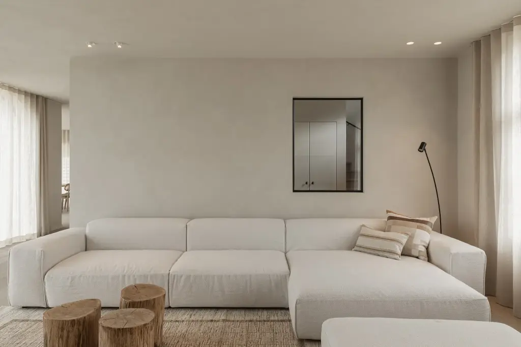 Witte hoekzetel met zwarte spiegel en boomstamtafeltjes, where architecture creates space for experience, interieur Laura Calleeuw