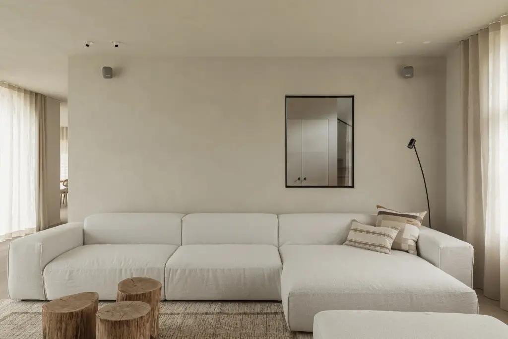 Witte hoekzetel met zwarte spiegel en boomstamtafeltjes, where architecture creates space for experience, interieur Laura Calleeuw