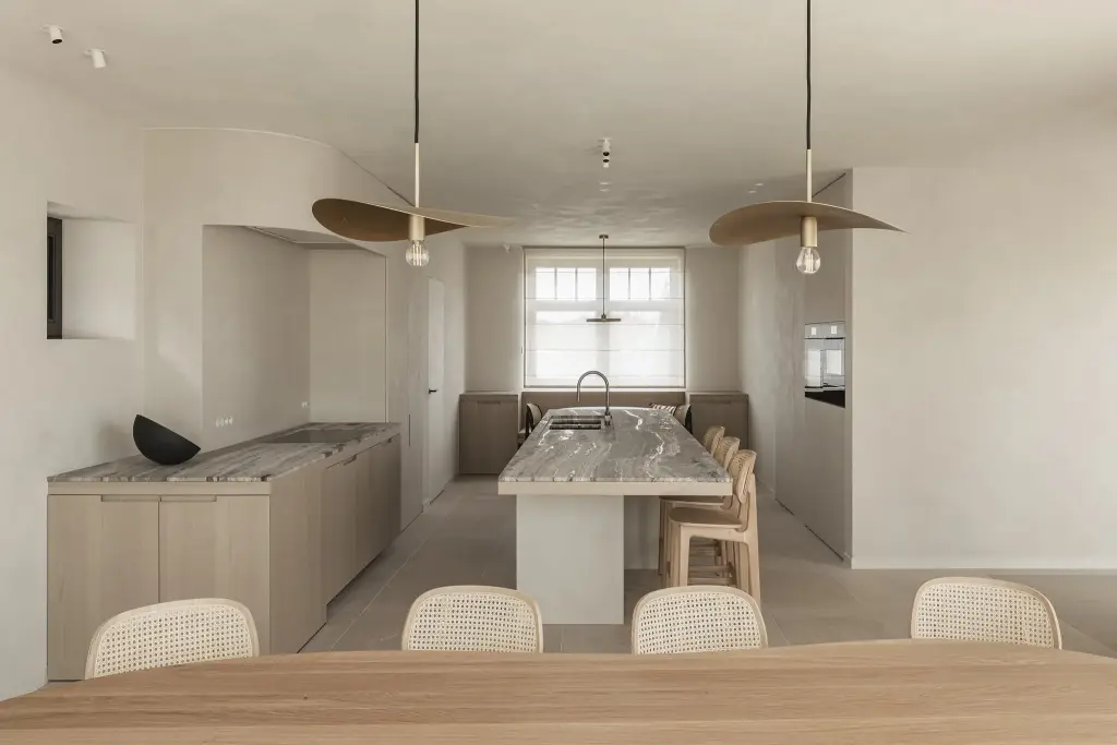 Keuken met eiland, twee hanglampen en doorkijk naar de eethoek, where architecture creates space for experience, interieur Laura Calleeuw