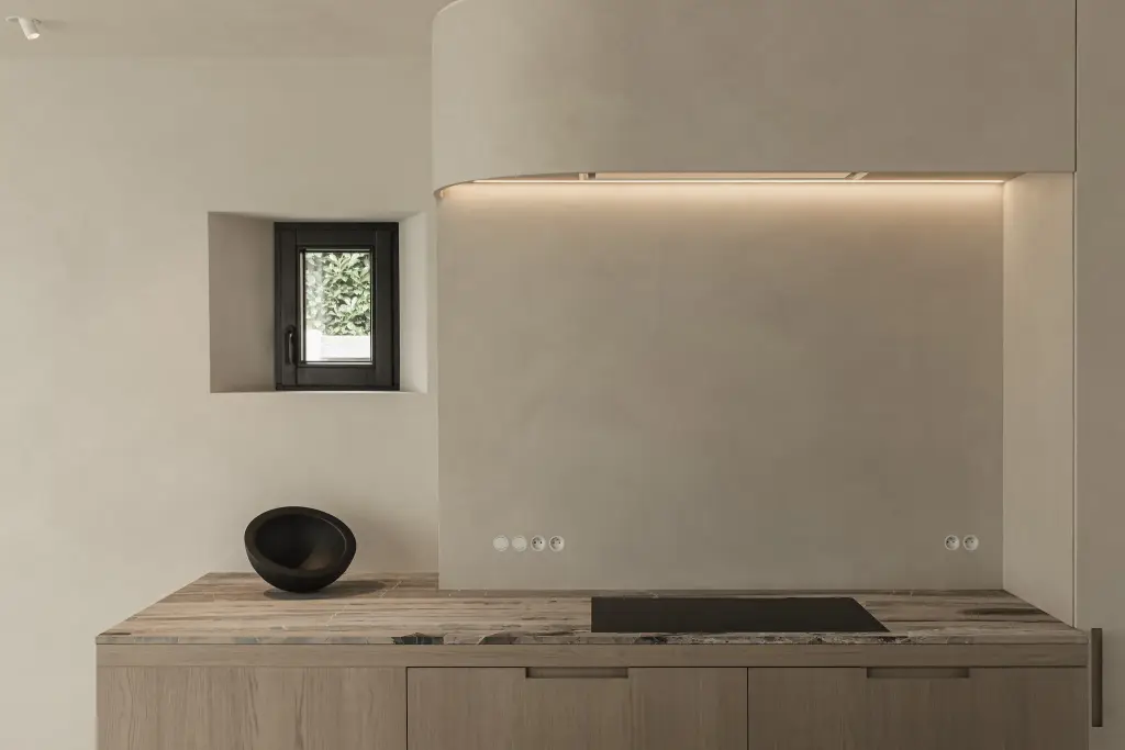 Keuken met kookplaat, klein venster in microcement nis en zwarte schaal, where architecture creates space for experience, interieur Laura Calleeuw