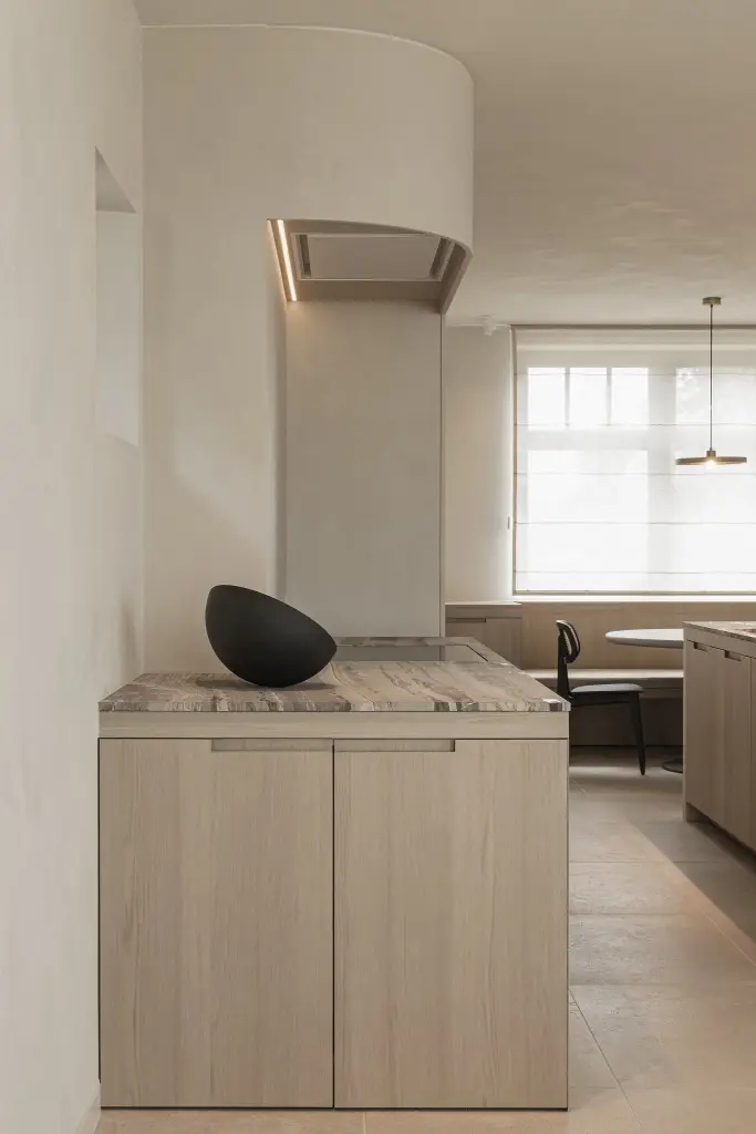 Keukenblok met afgeronde afzuigkap in microcement en zwarte schaal, where architecture creates space for experience, interieur Laura Calleeuw