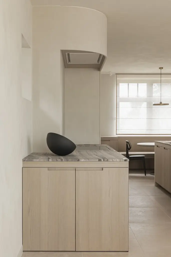Keukenblok met afgeronde afzuigkap in microcement en zwarte schaal, where architecture creates space for experience, interieur Laura Calleeuw