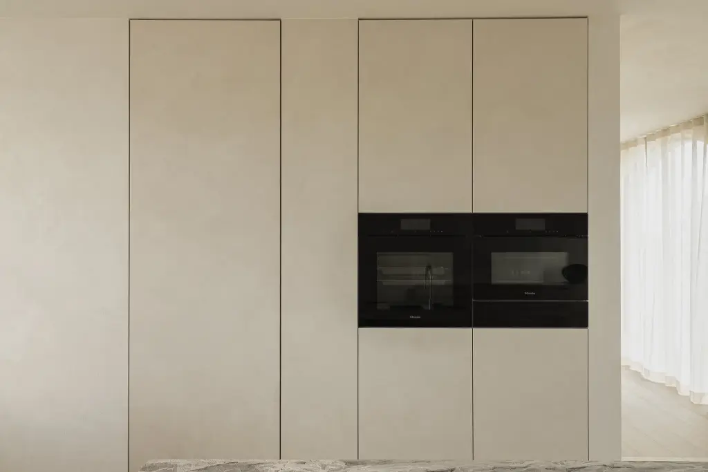 Keukenkastenwand in microcement met inbouwovens, where architecture creates space for experience, interieur Laura Calleeuw